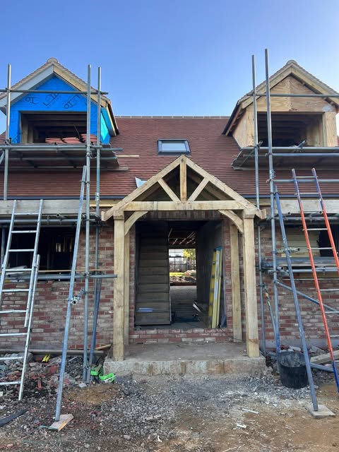 Bespoke oak porch frame fitted to the front of a house, with two dormers above